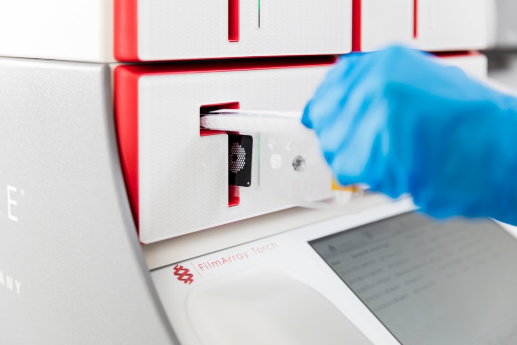 Person loading a syndromic testing pouch into a BioFire® System.
